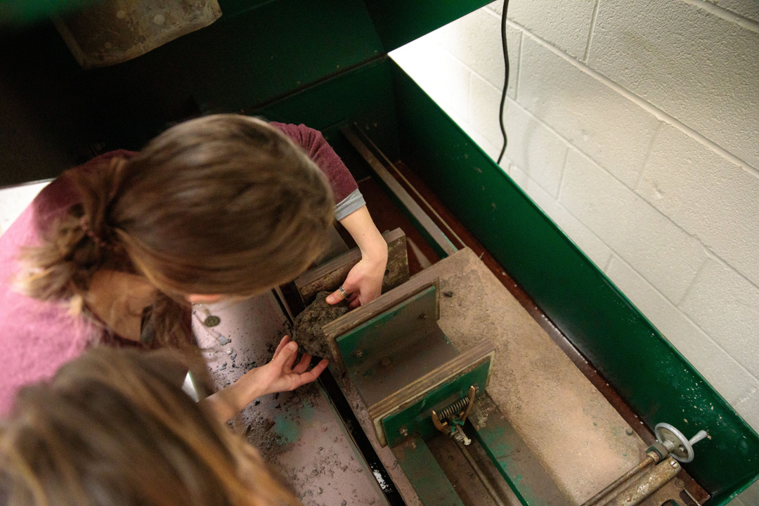geology students cut a sample of rock on a saw
